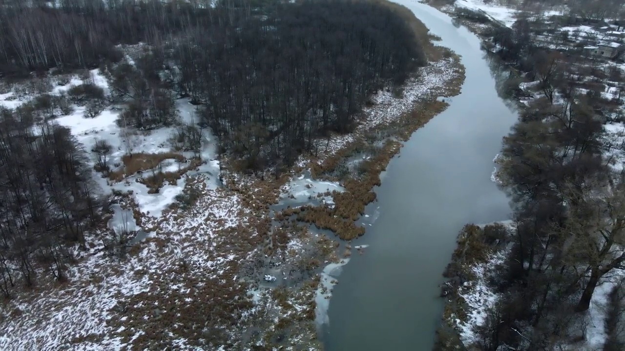 在白雪覆盖的城市公园里，在河上飞行。航空摄影。视频素材