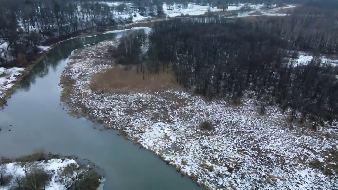 在白雪覆盖的城市公园里，在河上飞行。航空摄影。视频素材