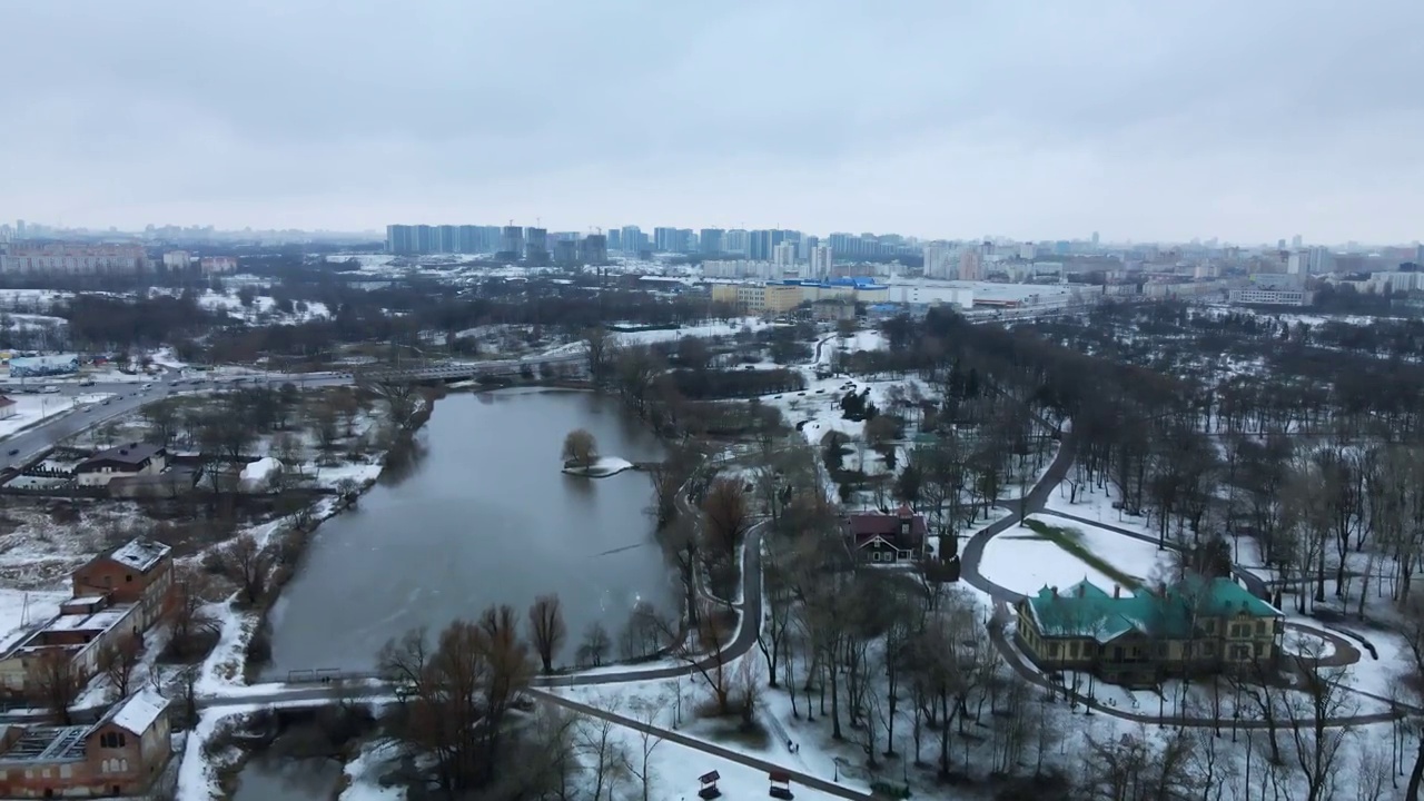 在白雪覆盖的城市公园里，在河上飞行。航空摄影。视频素材