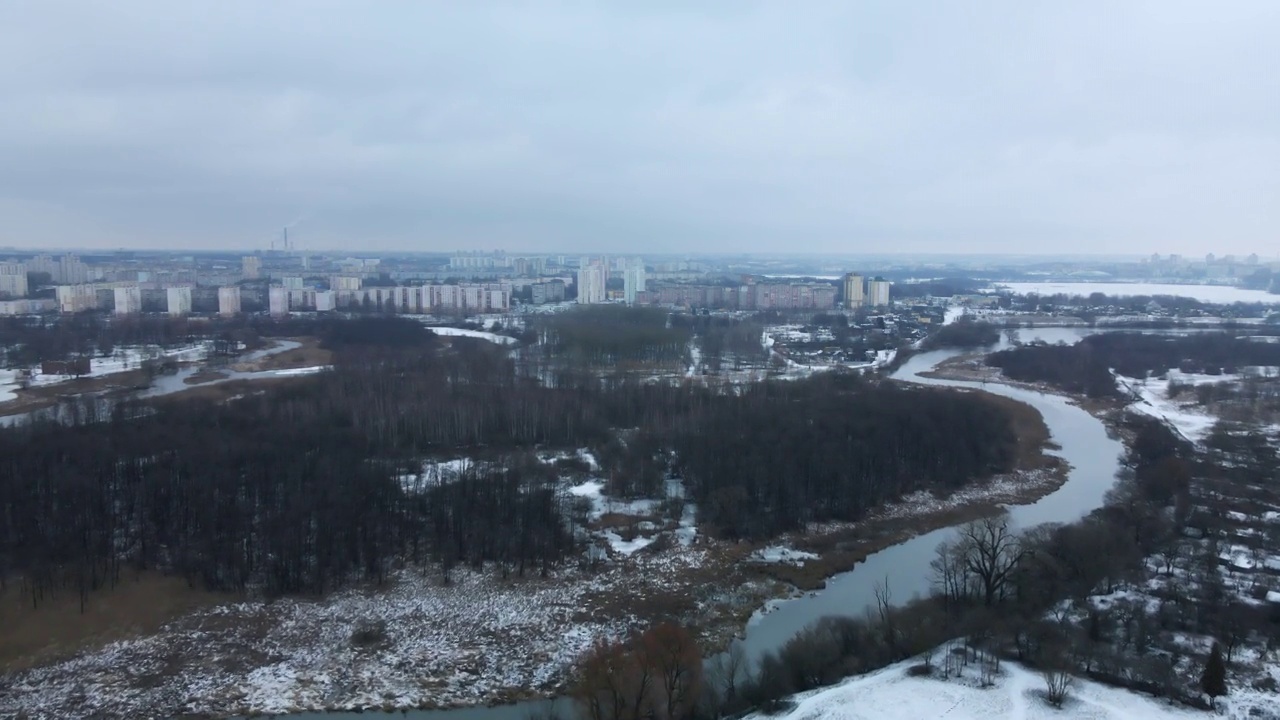 在白雪覆盖的城市公园里，在河上飞行。航空摄影。视频素材