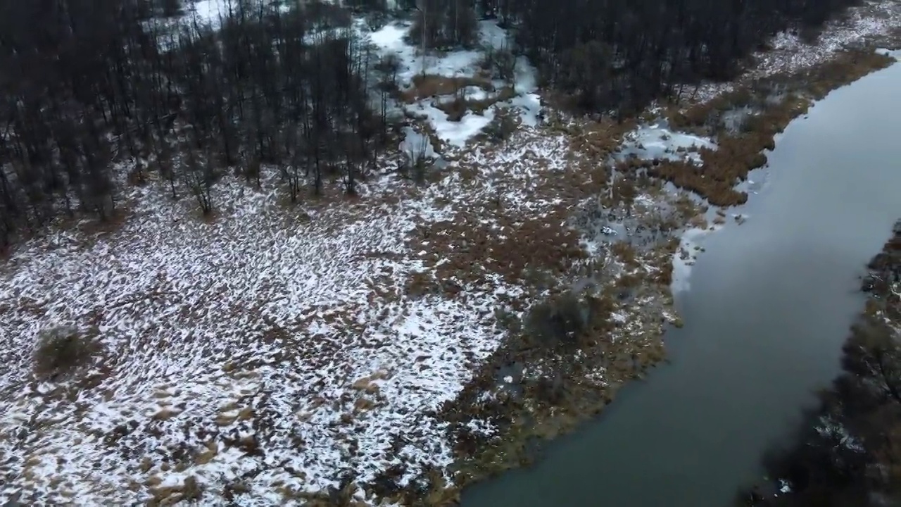 在白雪覆盖的城市公园里，在河上飞行。航空摄影。视频素材