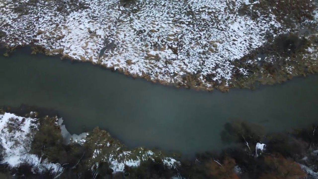 在白雪覆盖的城市公园里，在河上飞行。航空摄影。视频素材