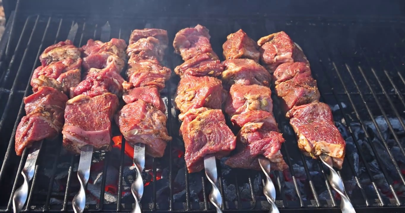 在美味的烤牛肉串上烧烤，烟从炭视频素材