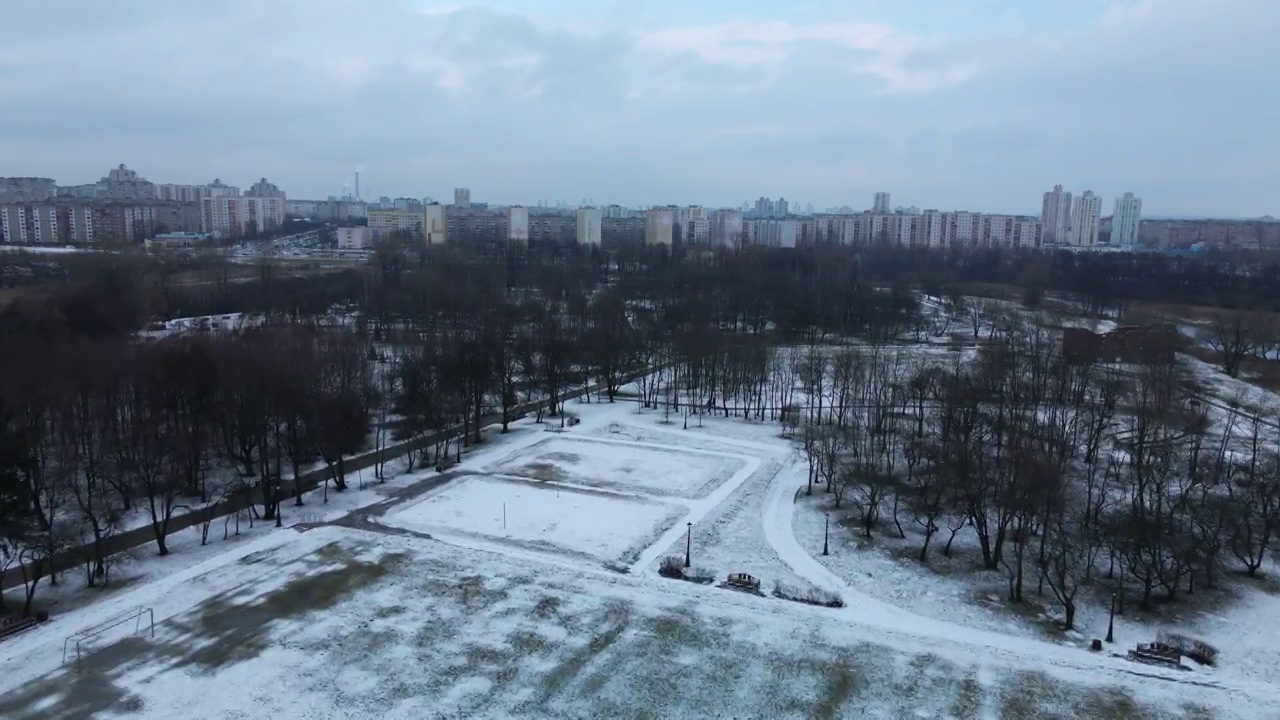 在冰雪覆盖的城市公园的运动场上空飞翔。航空摄影。视频素材