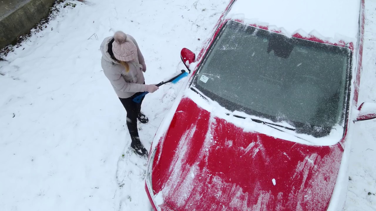 一个女人正在从车里铲雪视频素材