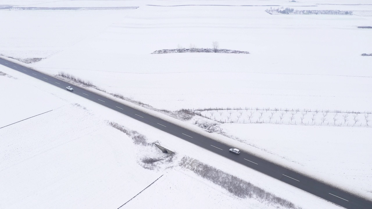 空中拍摄的汽车在白雪皑皑的冬天风景视频素材