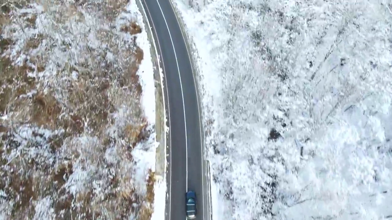 鸟瞰图的冬季道路与汽车和积雪覆盖的森林视频素材