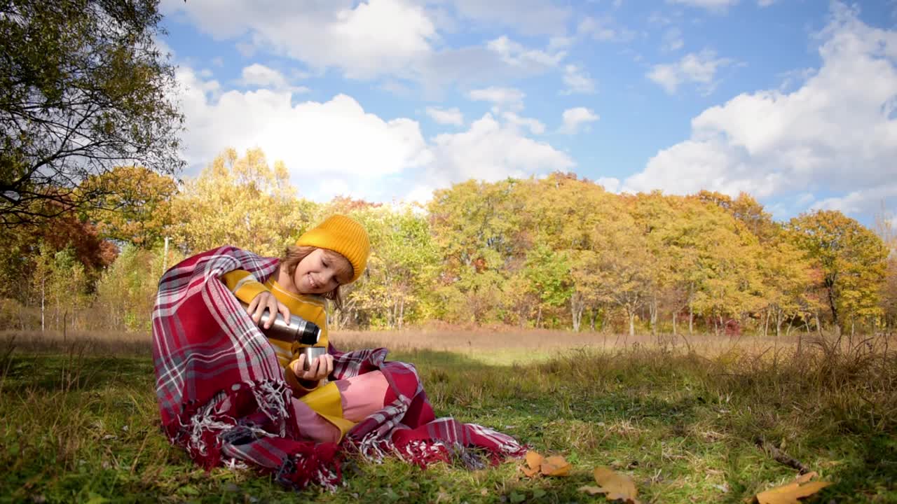 特写的女孩徒步旅行喝热茶和放松在秋天的森林在阳光明媚的秋天一天。健康，真实，平衡和冷静的感觉。慢动作视频。视频素材