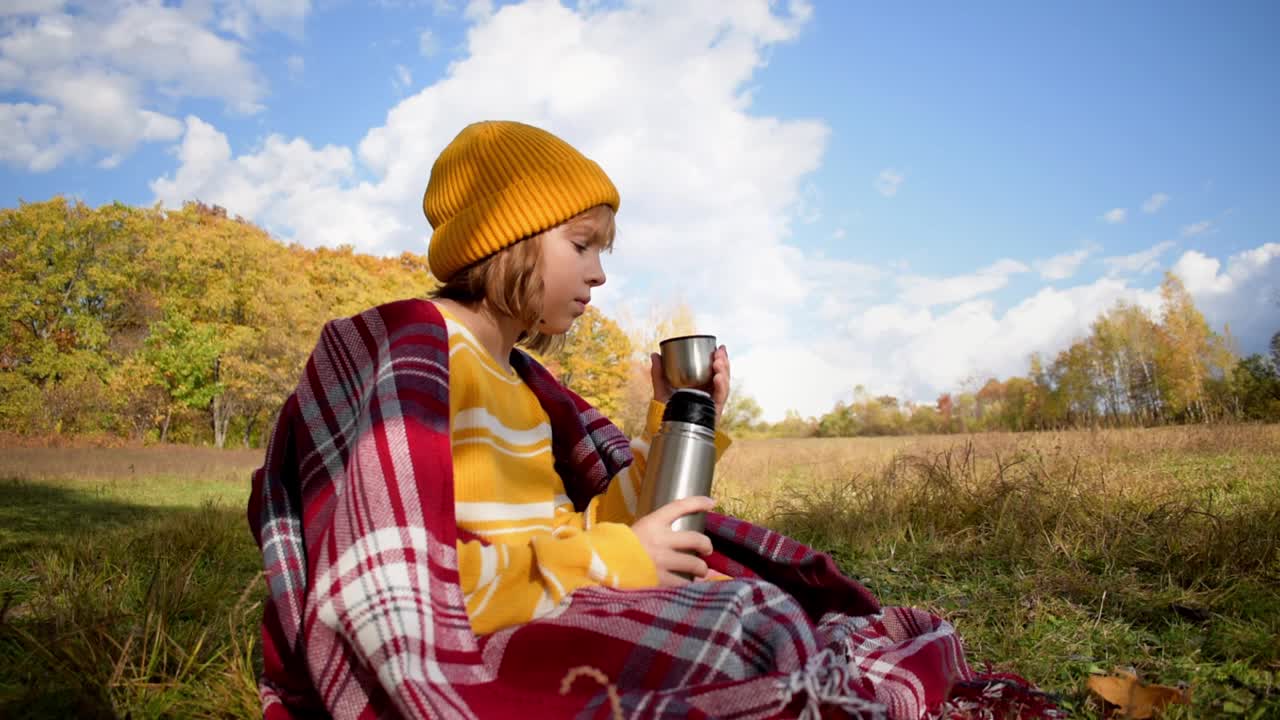 特写的女孩徒步旅行喝热茶和放松在秋天的森林在阳光明媚的秋天一天。健康，真实，平衡和冷静的感觉。慢动作视频。视频素材