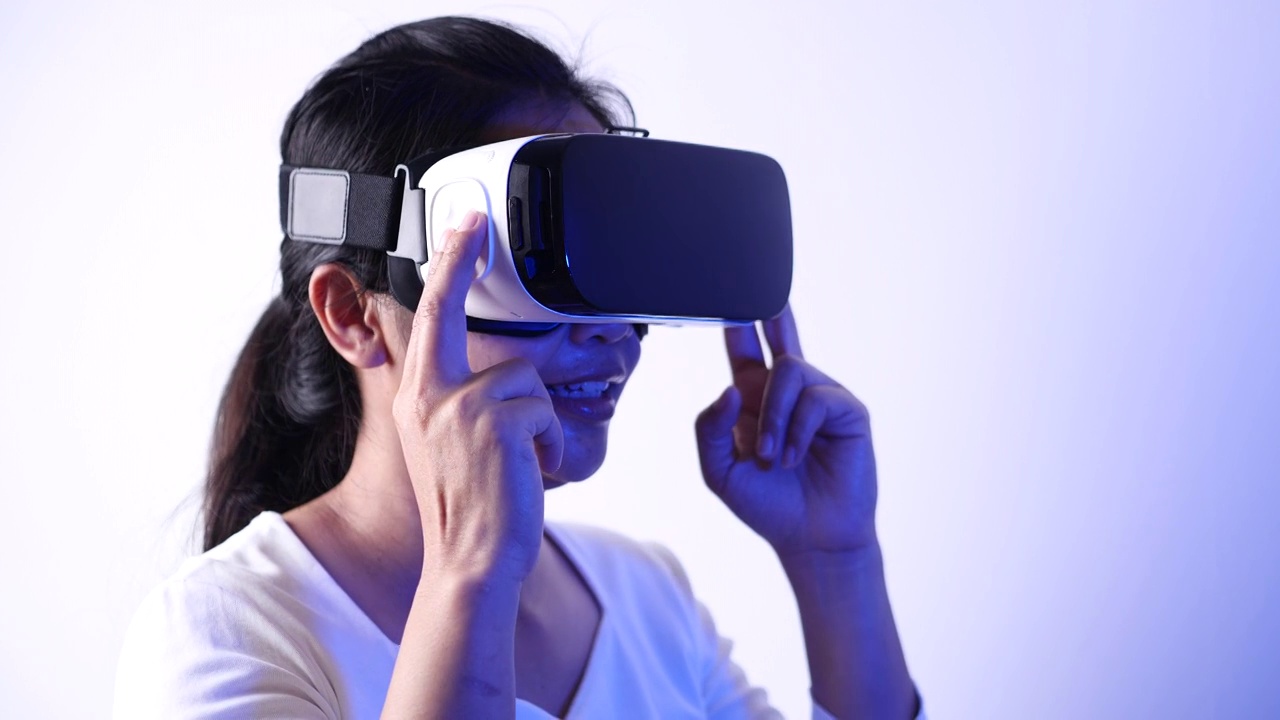 年轻女子在Metaverse体验VR时使用虚拟现实耳机触摸空气。VR(虚拟现实)，技术，视频游戏和元世界概念。视频素材