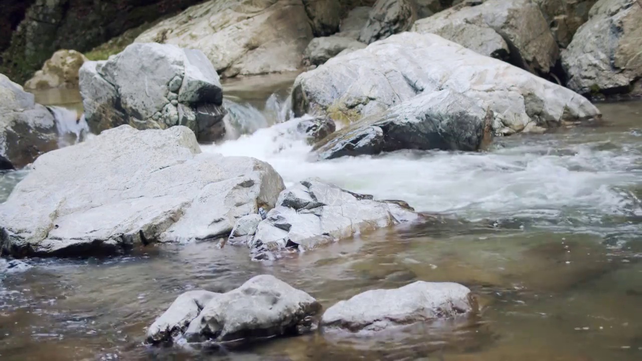 山涧的岩石。河水湍急地流着白色的浪花。视频素材