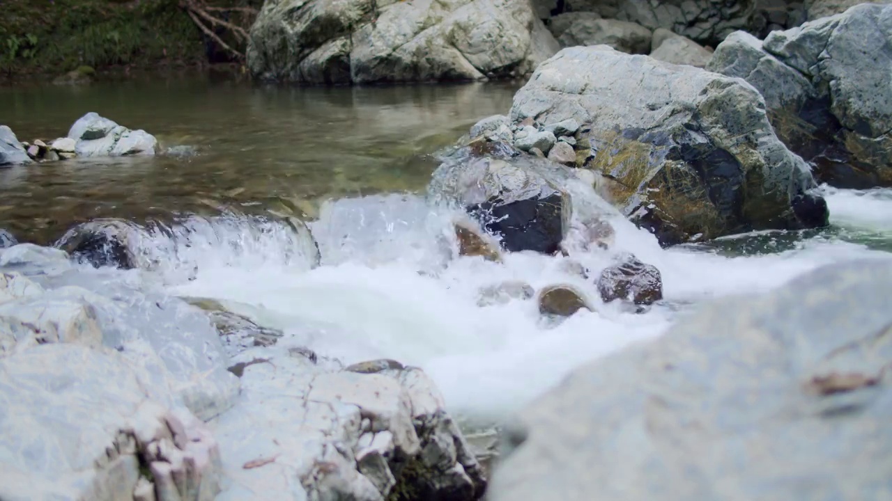 山涧的岩石。河水湍急地流着白色的浪花。视频素材