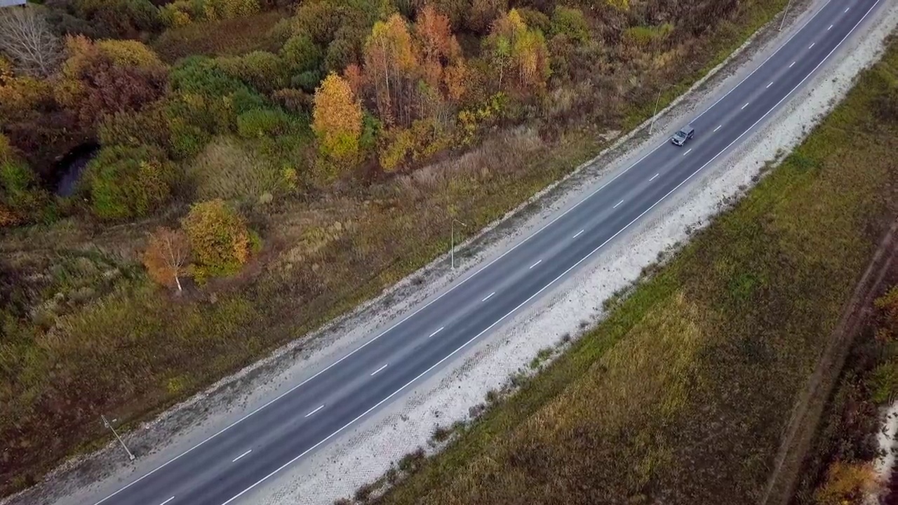 从高空俯瞰，一辆红色卡车驶离州际公路，驶向远方视频素材