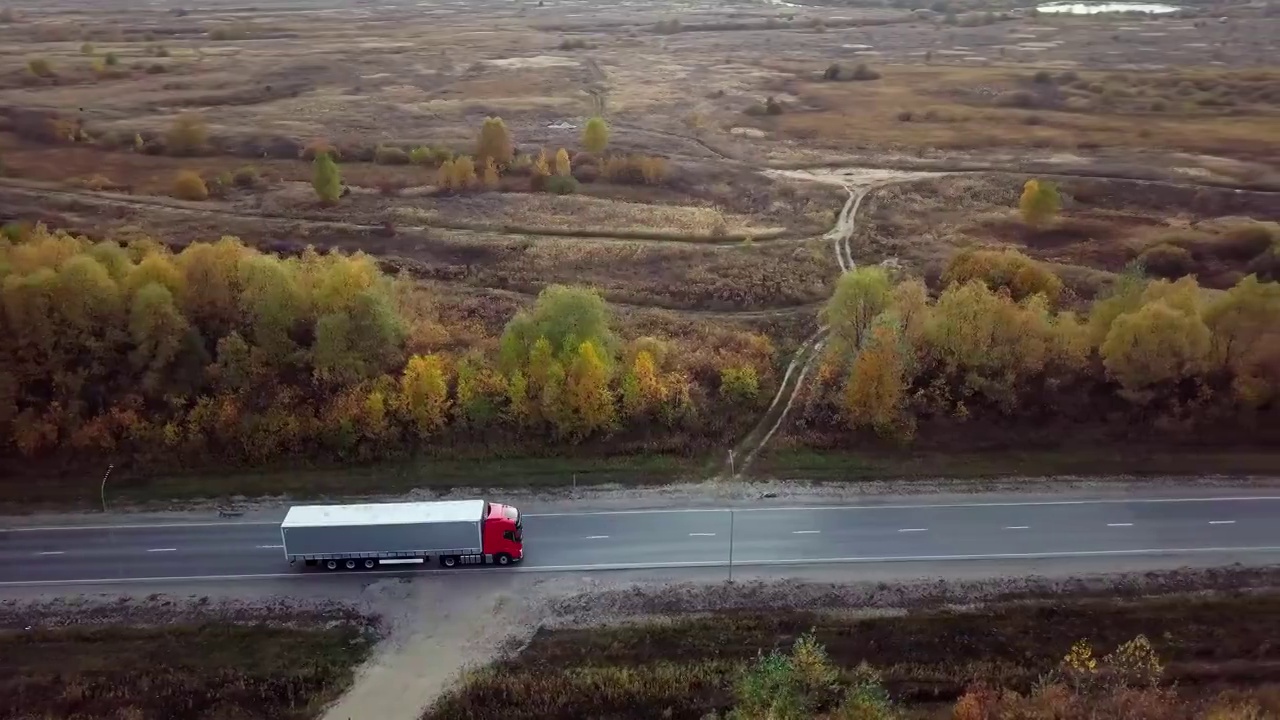 平头卡车的空中侧视图沿着高速公路与货物拖车。视频素材