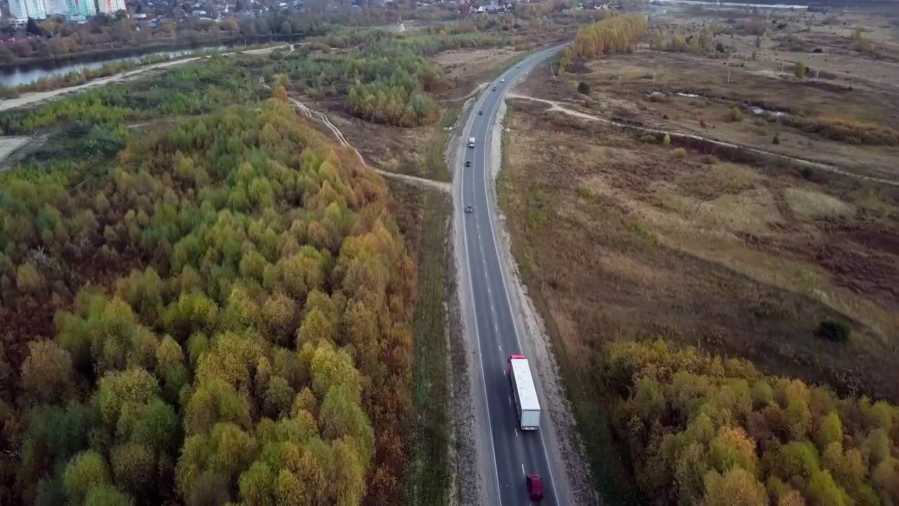 空中后侧视图的半卡车移动沿公路与货物拖车。视频素材