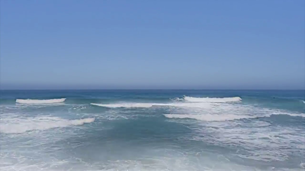 夏季阳光明媚的一天，塞浦路斯岛的沙滩上，巨大的海浪拍打着沙滩视频素材