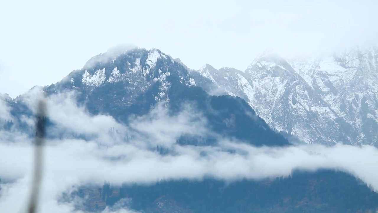 在印度喜马偕尔邦的马纳里雪暴期间，在喜马拉雅山脉的雪峰前的云流的时间推移。雪暴期间的云层逐渐消失视频素材