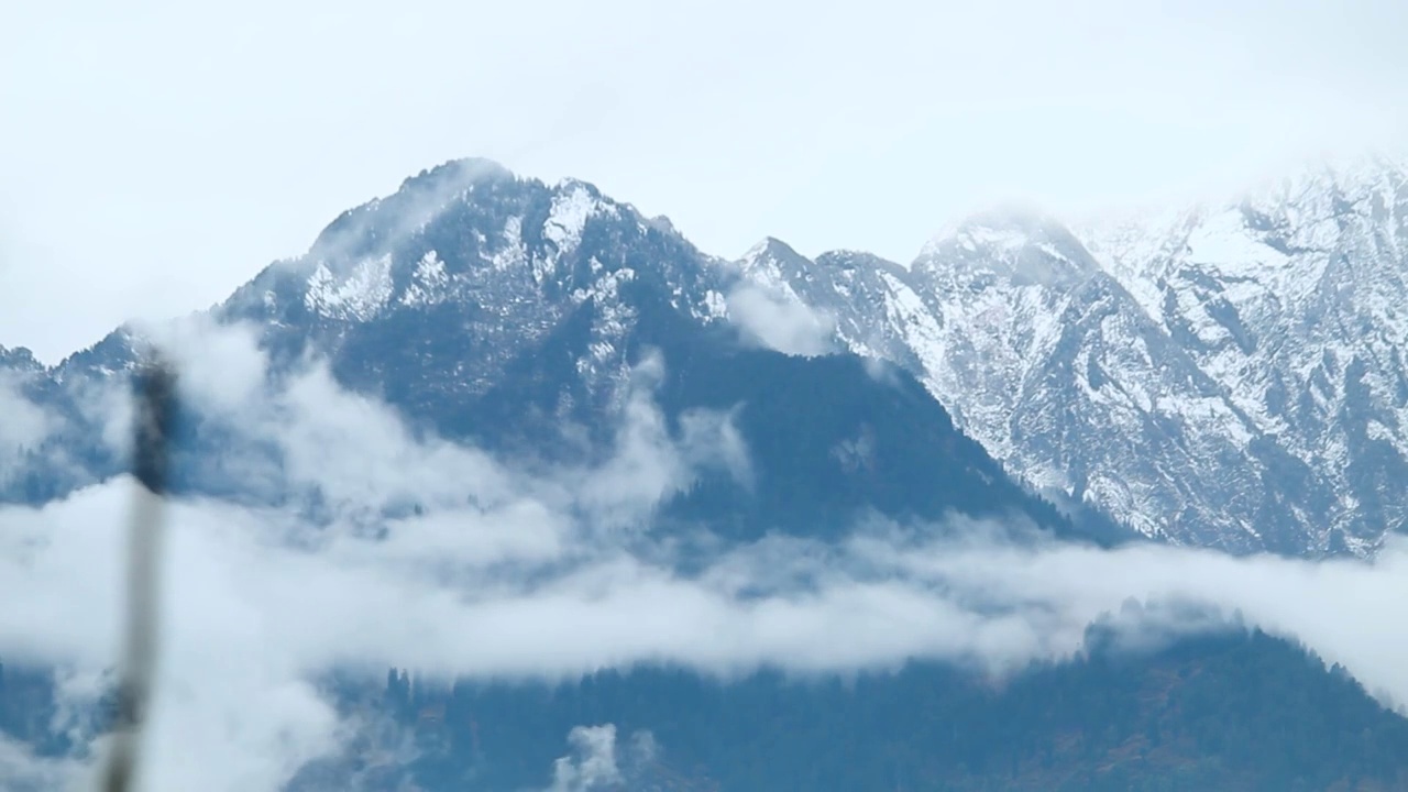 在印度喜马偕尔邦的马纳里雪暴期间，在喜马拉雅山脉的雪峰前的云流的时间推移。雪暴期间的云层逐渐消失视频素材