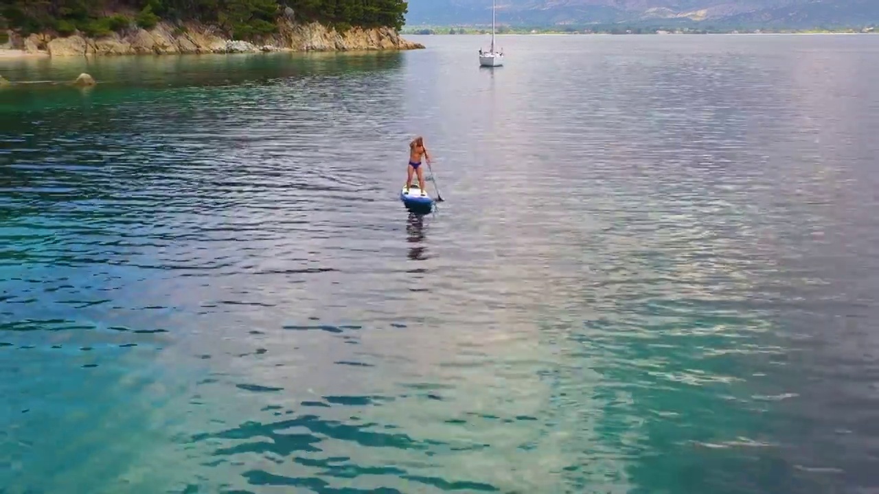 男子在美丽平静的海面上冲浪视频素材