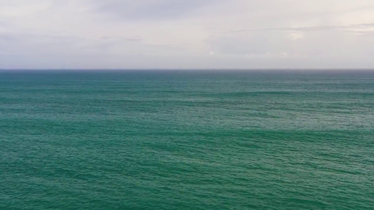 开阔的蓝色海洋，海浪映着天空和云彩视频素材