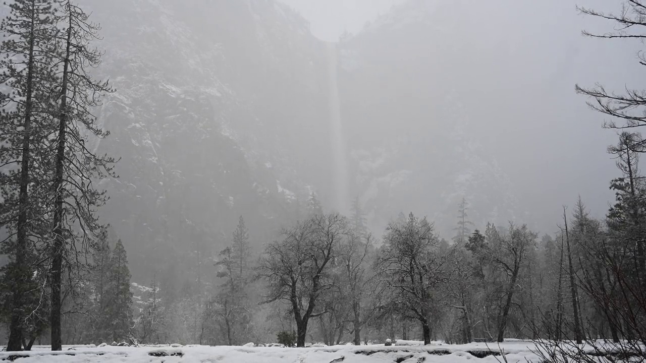 婚纱瀑布在雪雾中若隐若现视频素材