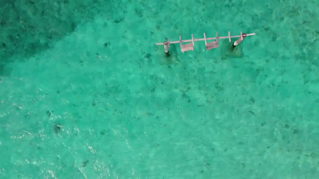 鸟瞰图秋千在马尔代夫清澈的海洋，波浪和阳光视频素材