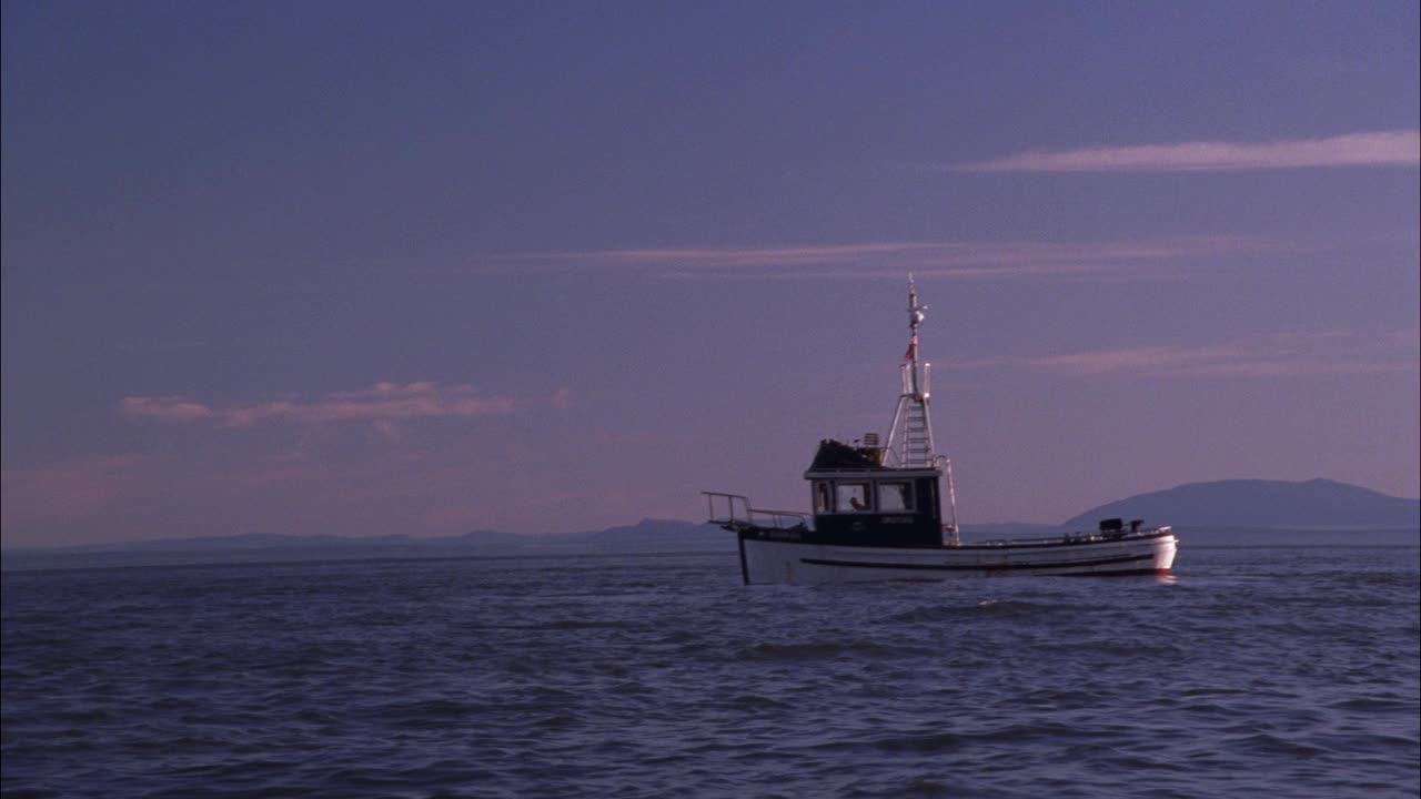 开阔的湖泊、海湾或海洋上的广角渔船。BG的山脉。云。小摩托艇上的男女或夫妇浮到渔船的一侧。视频素材