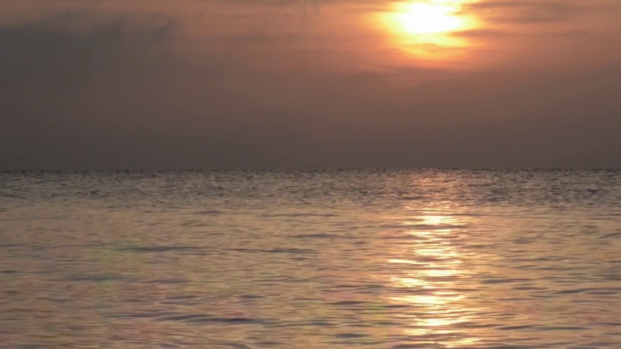 海面上的日出伴随着清晨的风产生的小波浪视频素材