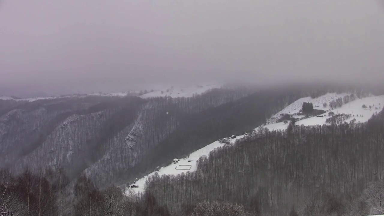 时间流逝，在寒冷的冬天，人们可以看到被白雪覆盖的山脉视频素材