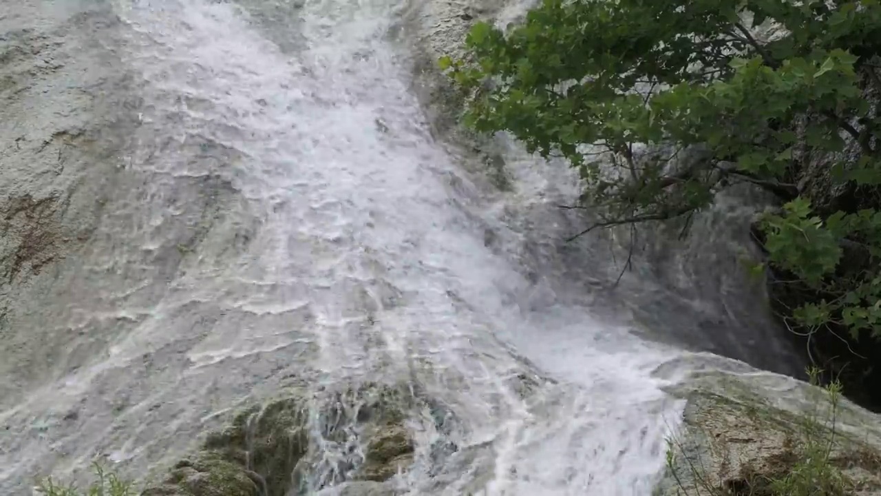 瀑布的水从倾斜的岩石上泻下视频素材