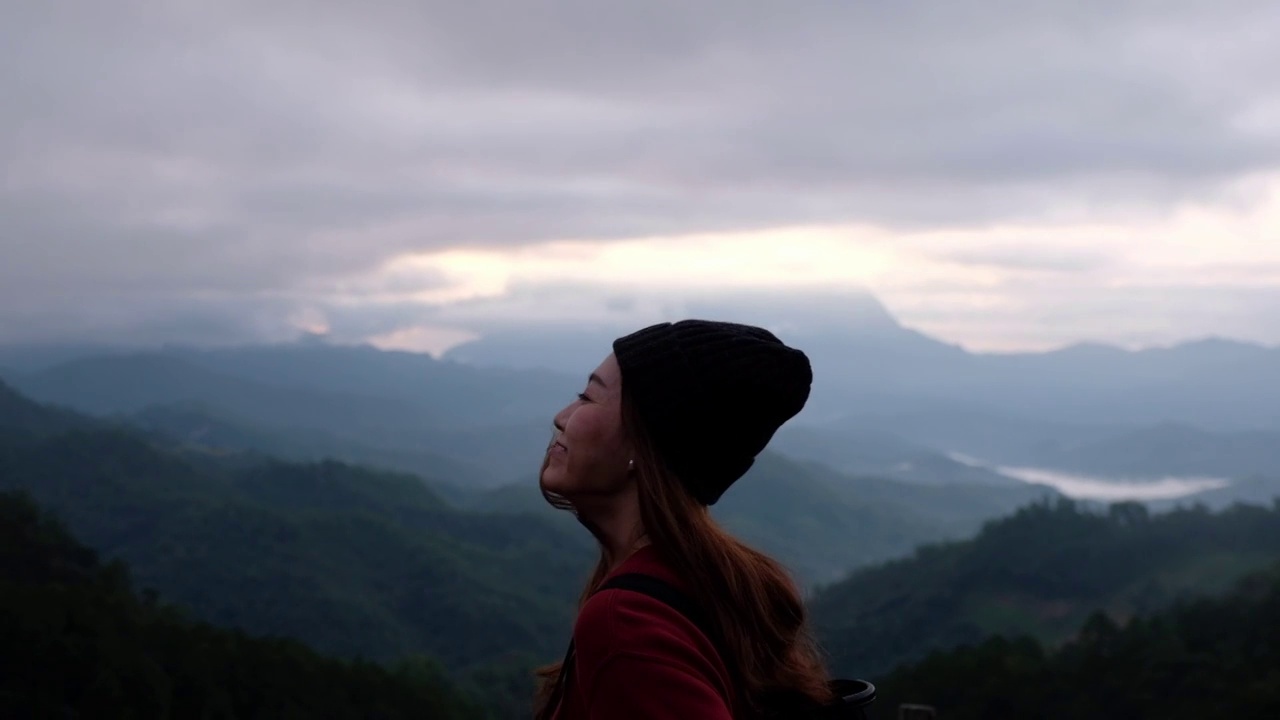 慢动作模糊的后视图，一个女性旅行者看着一个美丽的山景在雾天视频素材