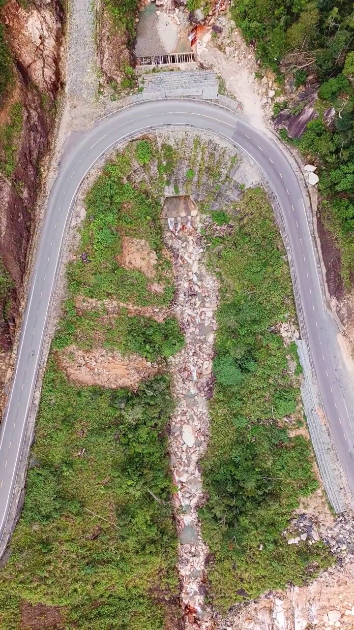 鸟瞰绿色丛林道路，度假，冒险。电影无人机拍摄飞越热带山区的砾石路景观。垂直视频。视频素材