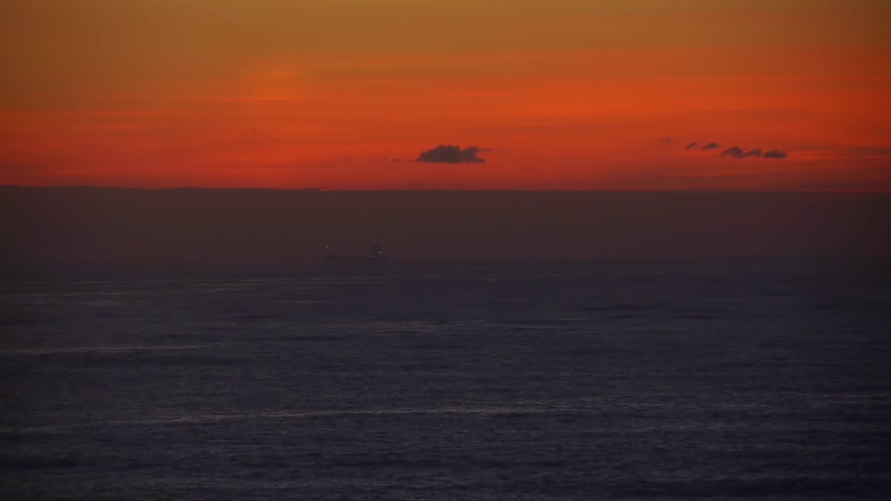 一个天空略带红色的早晨，横渡大西洋的船驶近了港口视频素材