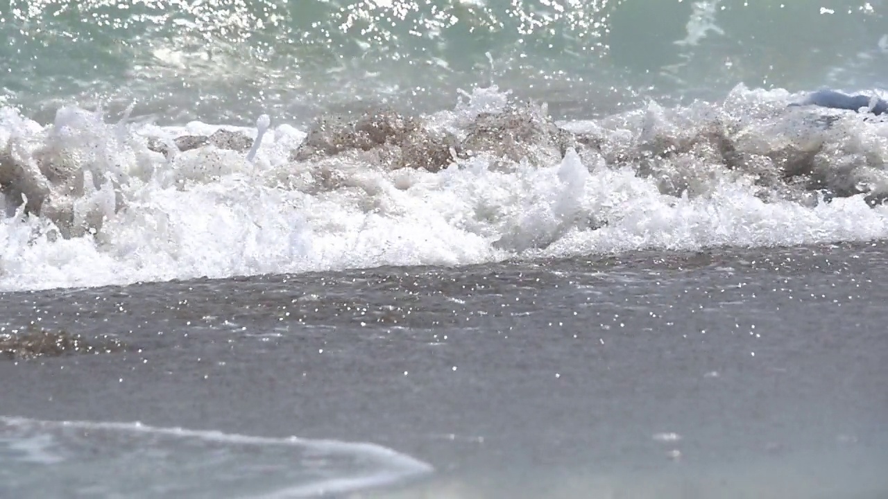 男人和女人在海边奔跑，沐浴在泡沫的海浪中视频素材