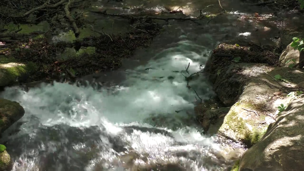 近距离拍摄，稳定的镜头，水从河流的岩石上倾泻而下视频素材