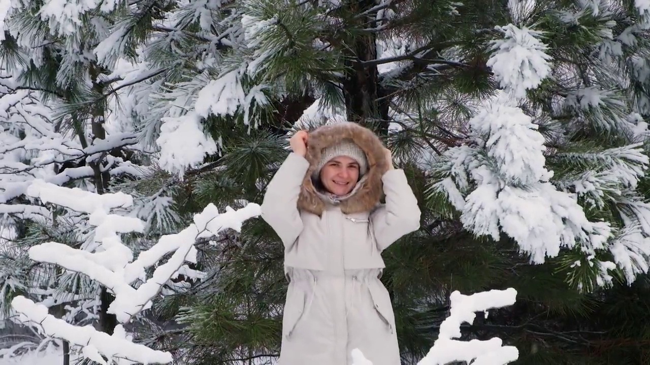 一个女人在冬天的雪原里跳跃嬉戏，雪花飞舞，慢动作视频素材