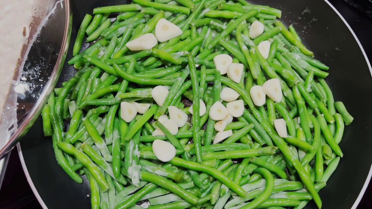 青豆和大蒜一起在煎锅里炸，用来做晚餐，健康饮食，无碳水化合物的食物视频素材