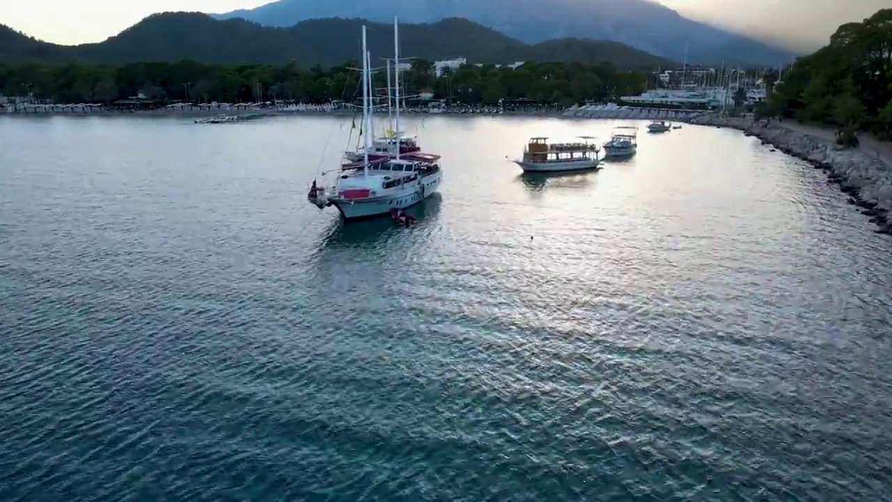 无人机飞行在水晶海水附近的游艇飞行的海鸥的框架视频下载