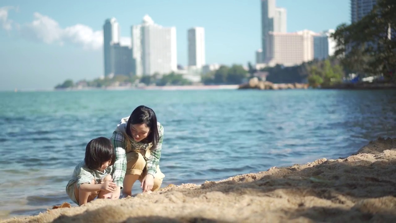 4K年轻的母亲和小女儿在海滩上享受假期视频素材