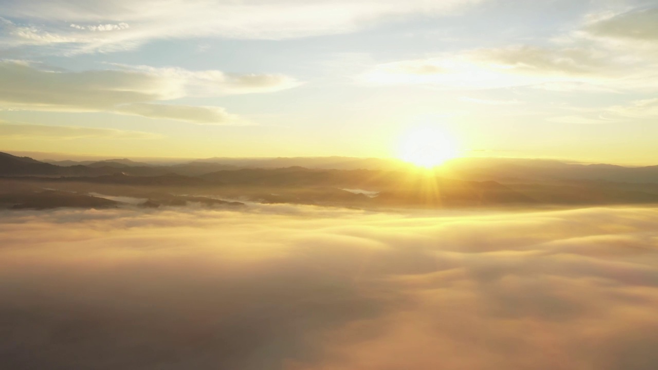 从空中俯瞰早晨从山上升起的太阳。美丽的云。视频素材