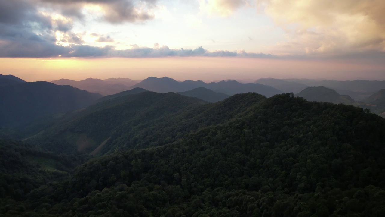 无人机在日落前的绿色雨林山脉的空中景观视图视频素材