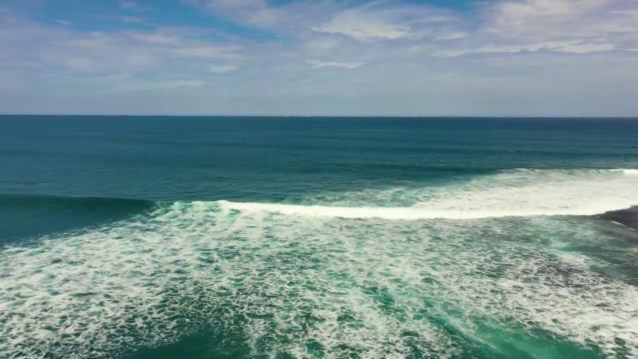 开阔的蓝色海洋，海浪映着天空和云彩视频素材