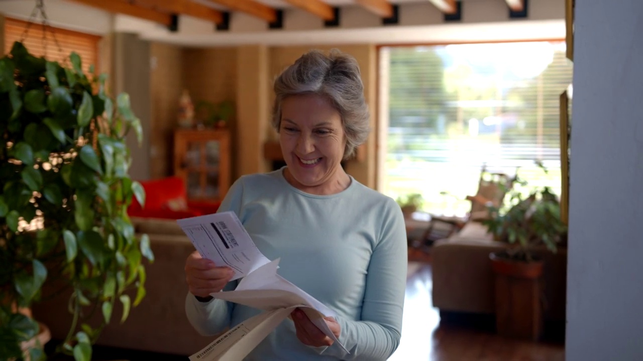 快乐的老女人在家里读一封她收到的信，非常兴奋视频素材