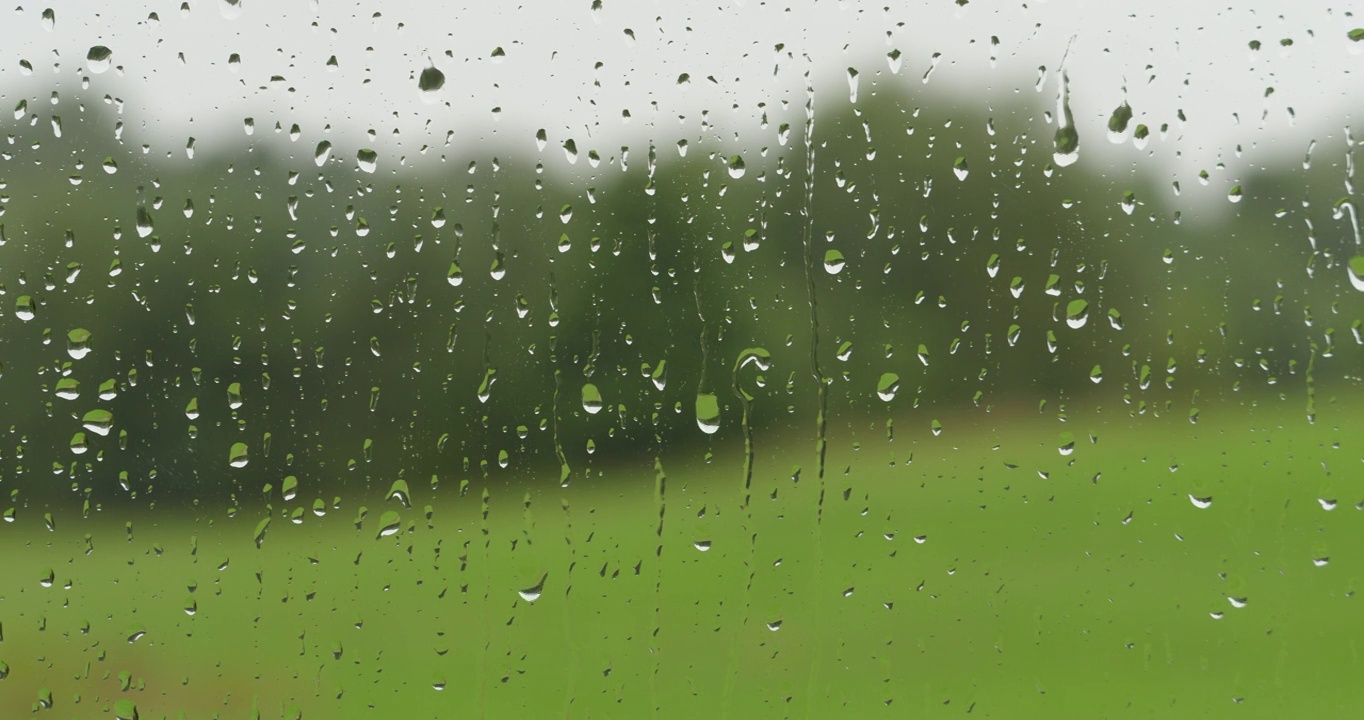 小雨打在玻璃上。夏天的雨雨滴沿着窗户落下。外面雨窗口。淋浴坏天气。平静放松的冥想宁静的背景。雨天，秋天，忧郁，悲伤，孤独视频素材