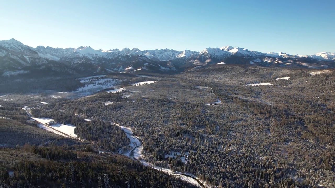 白雪皑皑的冬天和美丽的高山背景的风景。冰雪覆盖的冬季森林被雪覆盖。史诗般的未被破坏的冬季景观视频素材