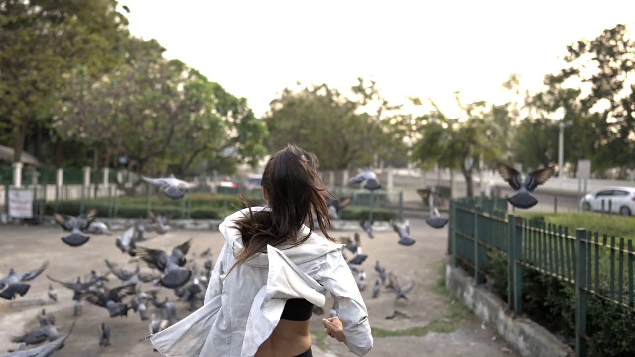 在夏天的日落时分，一名身着运动服的4K西班牙裔妇女在城市街道上慢跑。视频素材