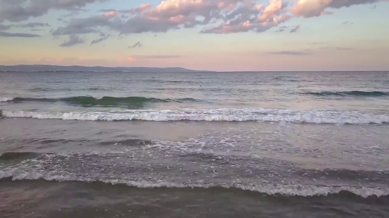 在日落的天空下，蓝色海浪的海面鸟瞰图。视频素材