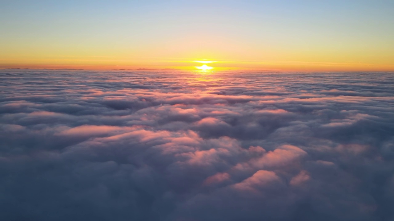 从高空俯瞰，浓密蓬松的积云在傍晚飞舞。从飞机窗口看到的令人惊叹的日落视频素材