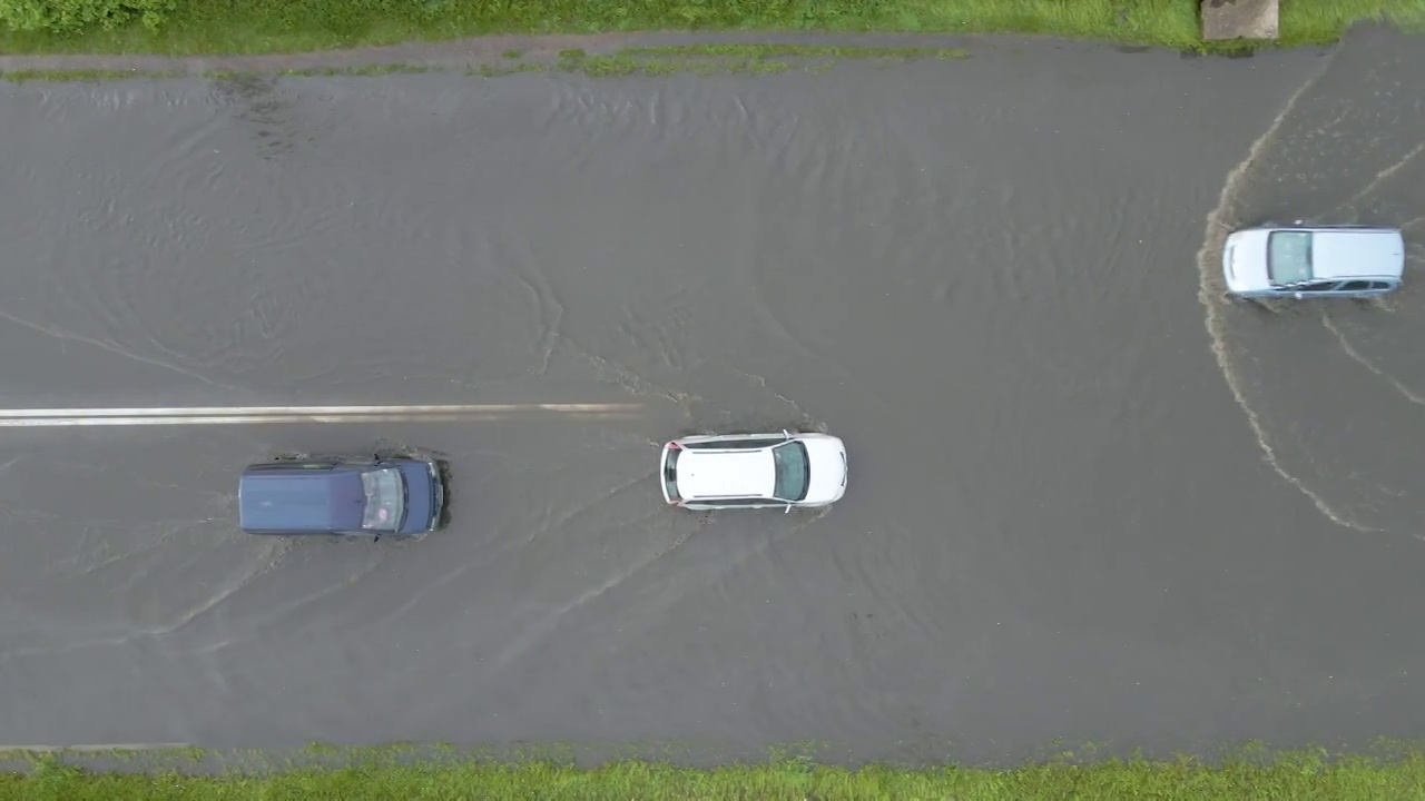 城市交通鸟瞰图，汽车行驶在暴雨后被淹没的街道上。道路排水系统的问题视频素材