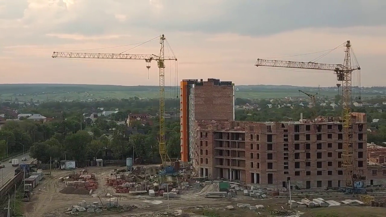 鸟瞰图建筑工地与建筑起重机和高层公寓在一个城市。视频素材